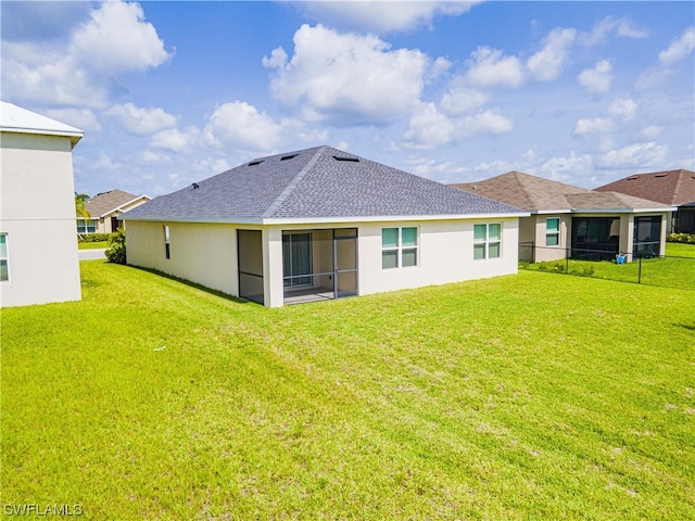 rear view of property featuring a lawn