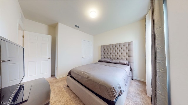 bedroom with a closet and light carpet