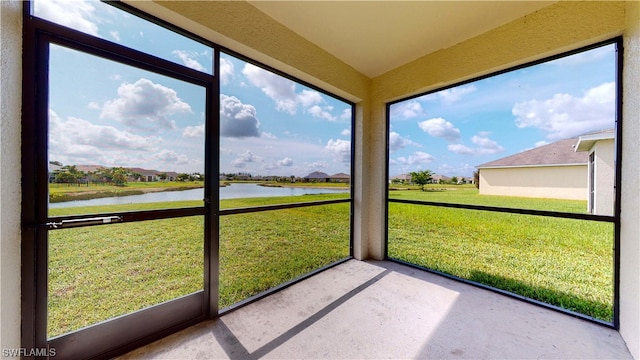 unfurnished sunroom featuring a water view