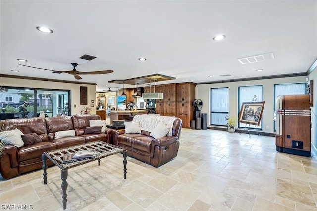 living room with ceiling fan, crown molding, and a wealth of natural light