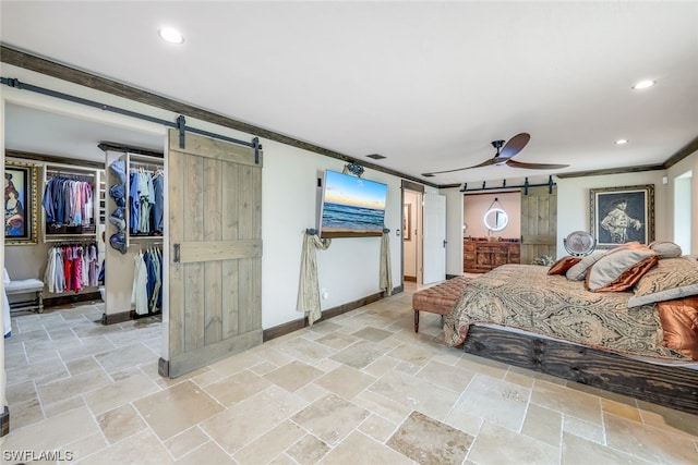 bedroom featuring ceiling fan, ornamental molding, and a barn door