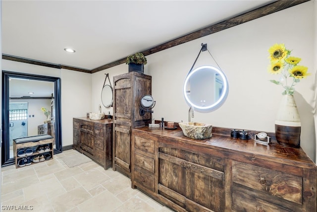 bar with ornamental molding, sink, and wood counters