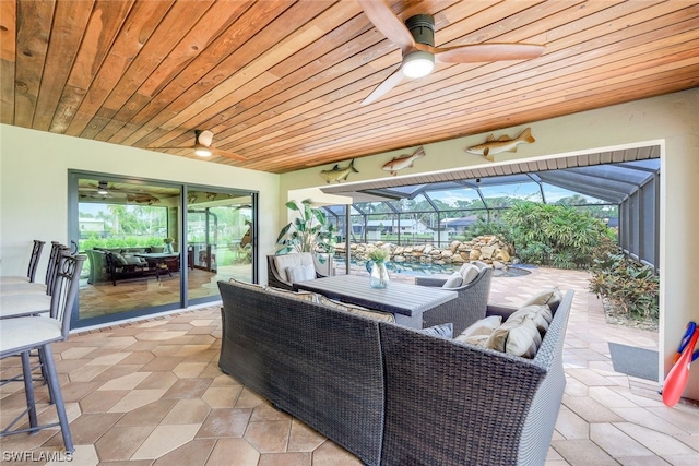 view of patio featuring ceiling fan, outdoor lounge area, and a lanai