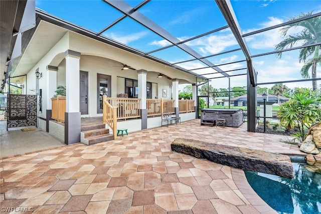 view of patio featuring ceiling fan, a lanai, and a hot tub