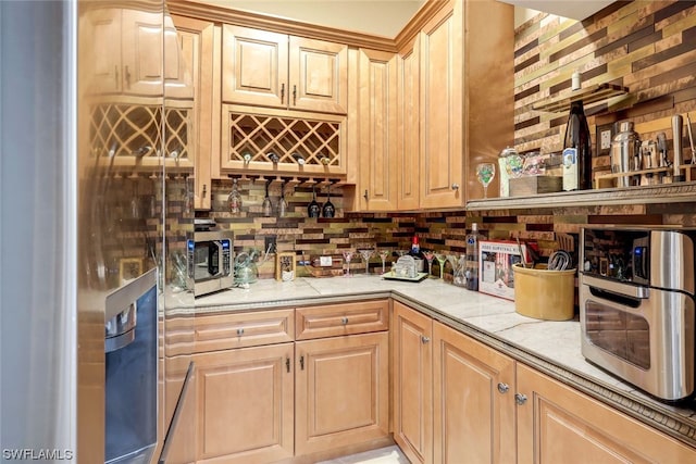 bar featuring decorative backsplash, light brown cabinetry, and appliances with stainless steel finishes