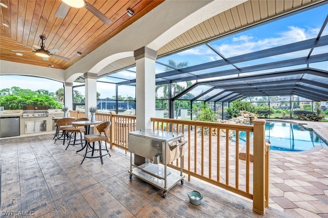 view of patio / terrace with ceiling fan, area for grilling, an outdoor kitchen, and a lanai