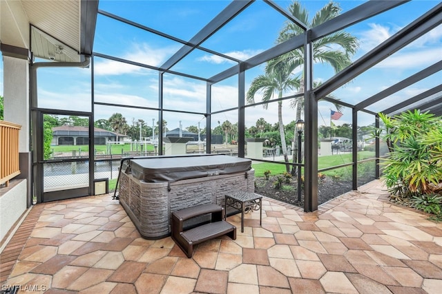 view of patio with a lanai, a water view, and a hot tub