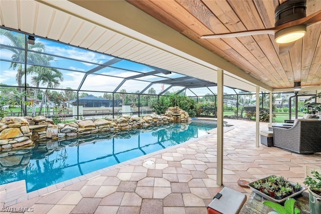 view of swimming pool with glass enclosure and a patio area