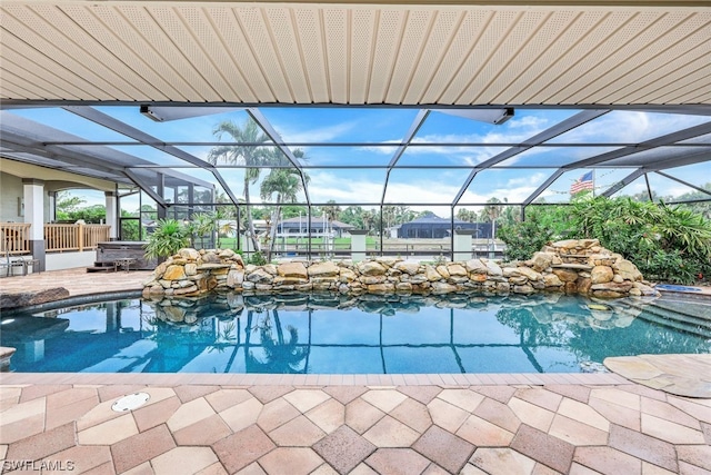 view of pool with a hot tub, a patio area, and a lanai