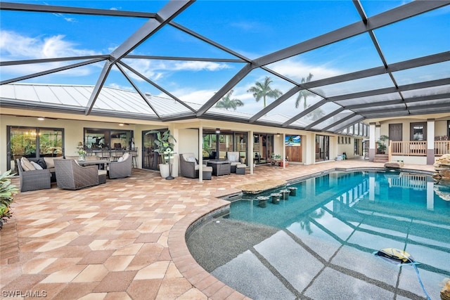 view of pool featuring outdoor lounge area, a patio, and glass enclosure