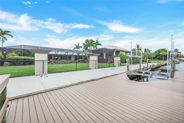 dock area with a lanai, a water view, and a lawn