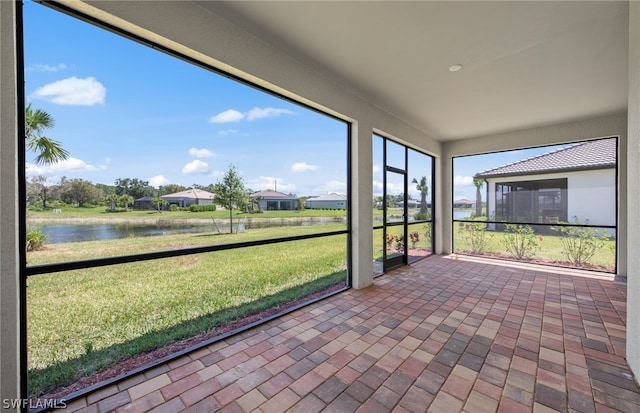 unfurnished sunroom featuring a water view