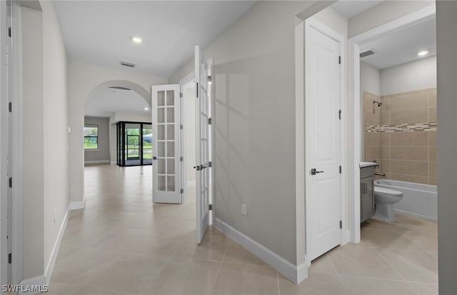 hall with french doors and light tile floors