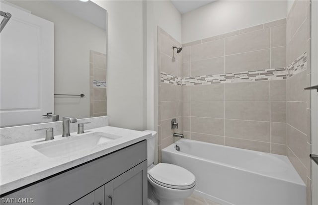 full bathroom featuring tiled shower / bath, large vanity, and toilet