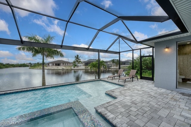 view of swimming pool with a patio area, a hot tub, glass enclosure, and a water view