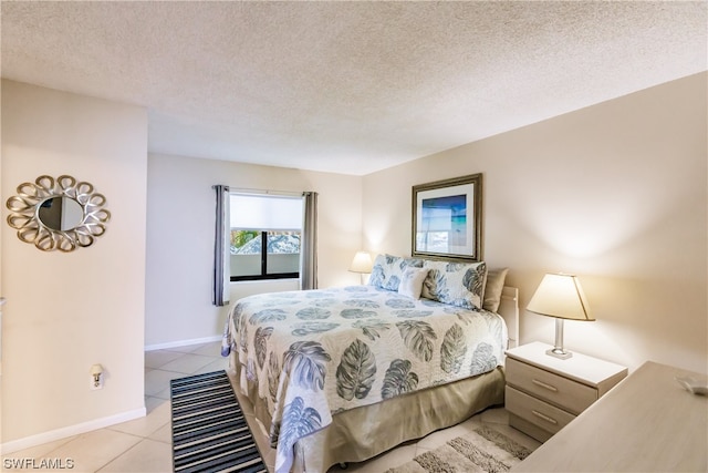 bedroom with a textured ceiling and light tile floors