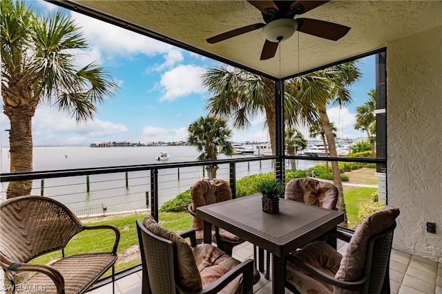 balcony featuring ceiling fan and a water view