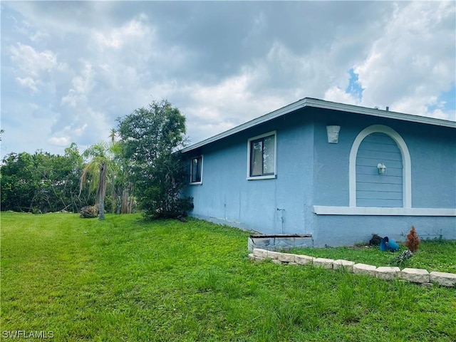 view of side of property with a lawn