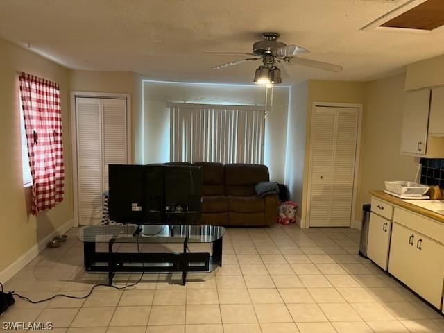 tiled living room with sink and ceiling fan