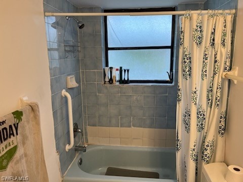 bathroom with shower / bath combination with curtain and toilet