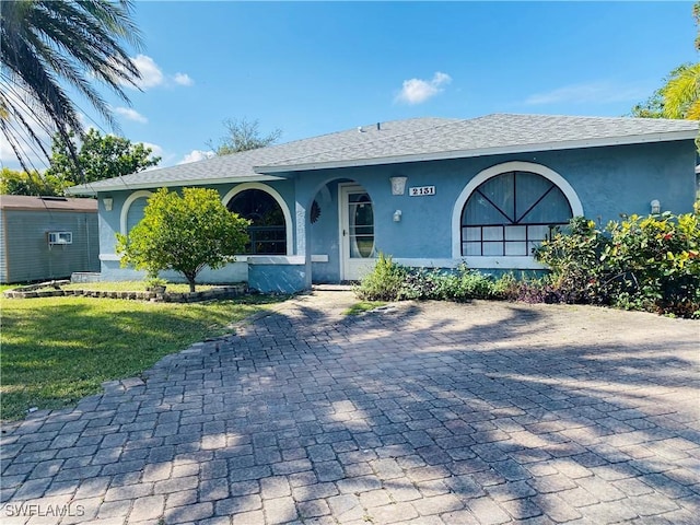 single story home featuring a front lawn