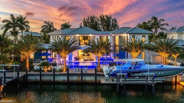 back house at dusk featuring a water view