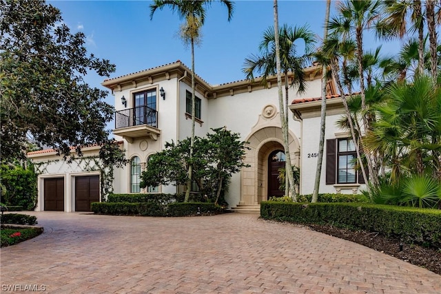 mediterranean / spanish-style home with a garage and a balcony