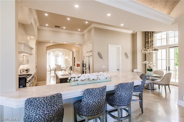 kitchen with a high ceiling, kitchen peninsula, stove, and a breakfast bar area