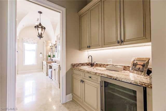 bar featuring hanging light fixtures, cream cabinets, beverage cooler, and light stone counters