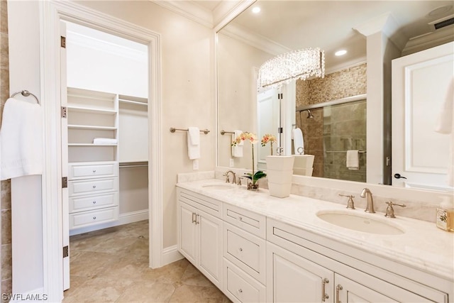 bathroom with vanity, a shower with shower door, and ornamental molding