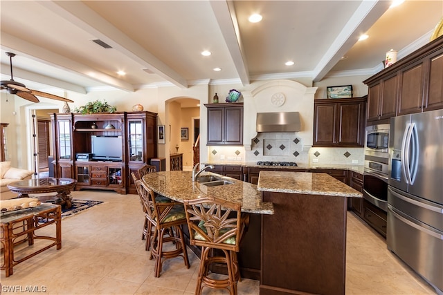 kitchen featuring a spacious island, beamed ceiling, sink, and stainless steel appliances