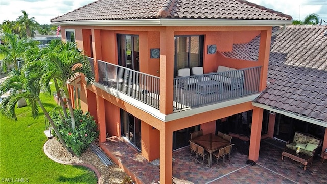 rear view of property with a patio area and a balcony