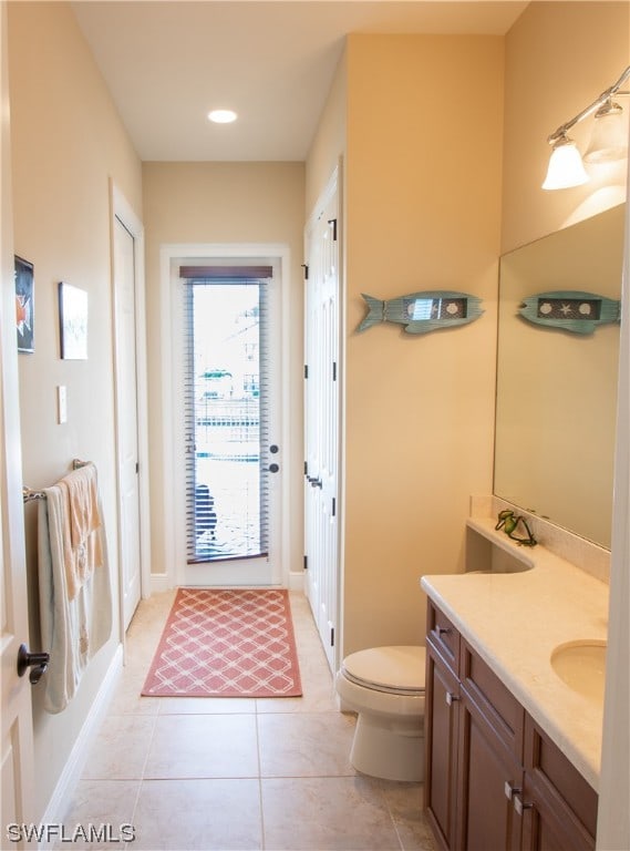 bathroom featuring toilet, vanity, and tile patterned flooring