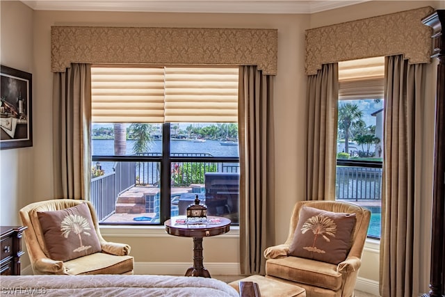 living area with crown molding and a water view