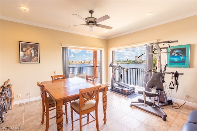 tiled dining area with crown molding, a water view, and ceiling fan