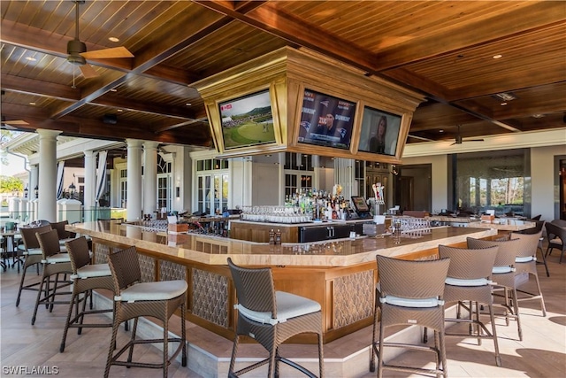 bar featuring ornate columns, coffered ceiling, a wealth of natural light, and wood ceiling