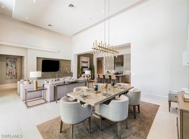 tiled dining space with a notable chandelier and a towering ceiling