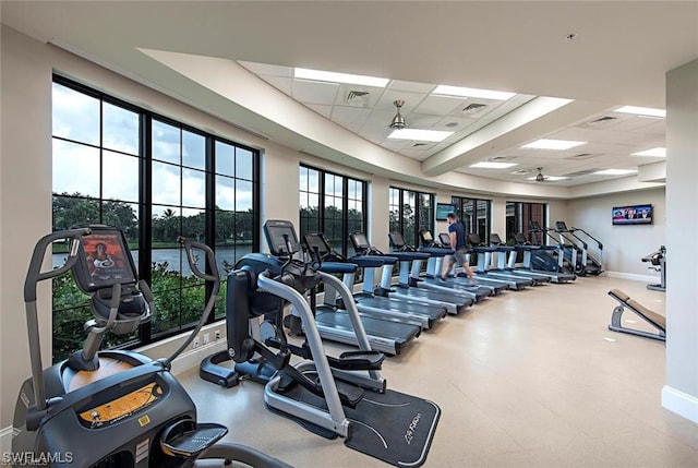 exercise room with a paneled ceiling and ceiling fan