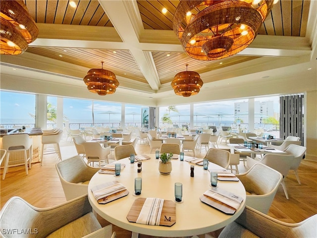 dining space featuring beamed ceiling, ornamental molding, coffered ceiling, and light parquet floors