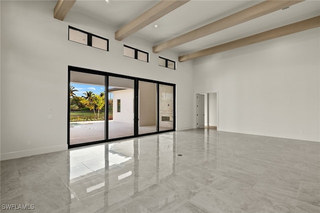 spare room with a high ceiling and beam ceiling