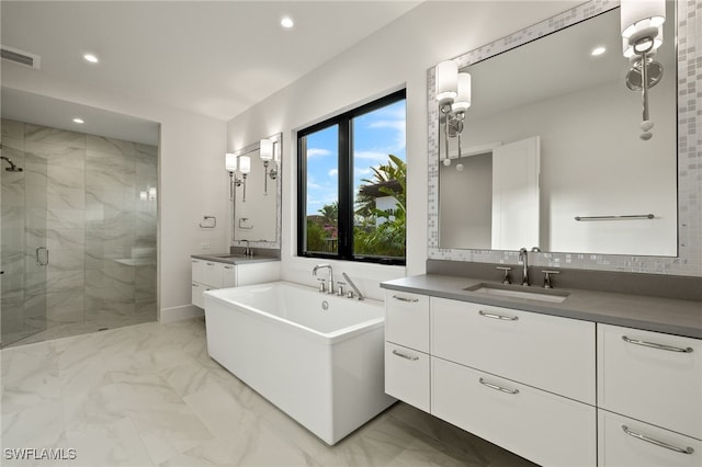 bathroom with tasteful backsplash, vanity, and independent shower and bath