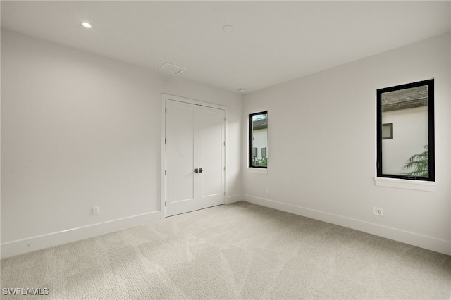 spare room featuring light colored carpet