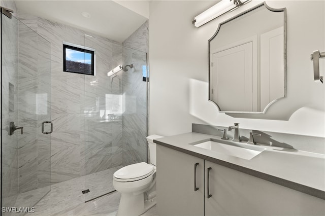 bathroom with vanity, a shower with door, and toilet