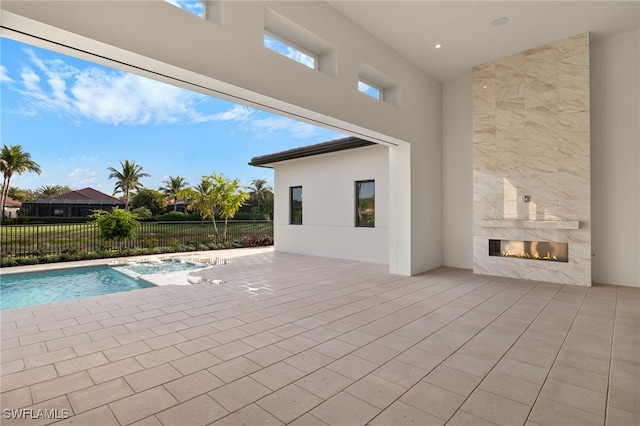 view of swimming pool with a patio area and a tile fireplace