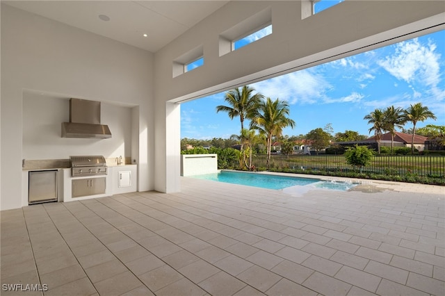 view of pool with pool water feature, area for grilling, and grilling area