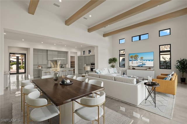 living room with a towering ceiling and beam ceiling