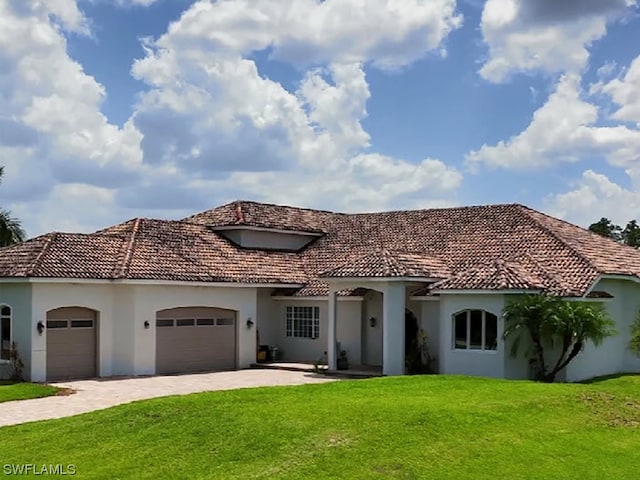 mediterranean / spanish-style house featuring a front lawn and a garage