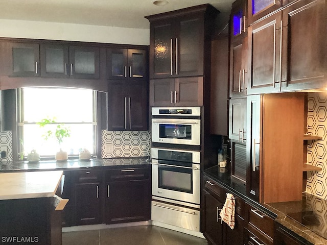 kitchen featuring backsplash, double oven, and dark brown cabinetry