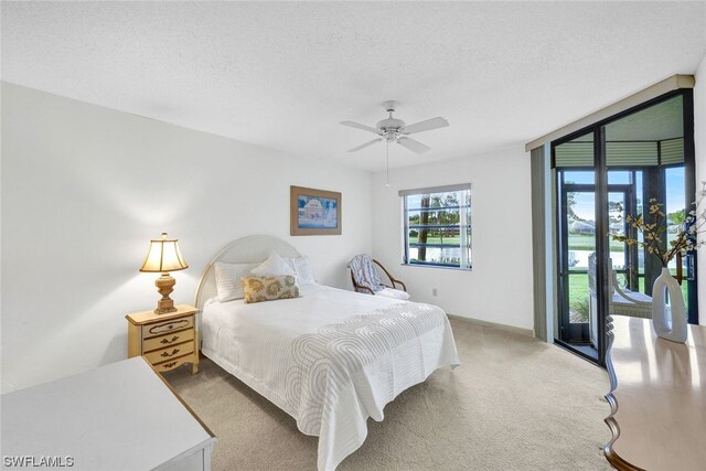 carpeted bedroom featuring ceiling fan, access to exterior, and a textured ceiling