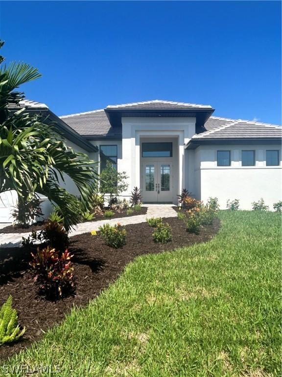 view of front of home featuring a front yard and french doors